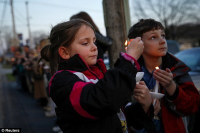 Ashlin (L) and Jude Burkhart, from Murrysville, hold candles during a prayer vigil for victims of the Franklin Regional High School stabbing rampage, at Calvary Lutheran Church in Murrysville, Pennsylvania April 9, 2014. A 16-year-old student wielding two knives went on