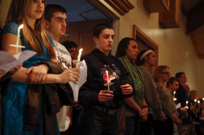 People hold candles during a prayer vigil for victims of the Franklin Regional High School stabbing rampage, at Mother of Sorrows Roman Catholic Church in Murrysville, Pa., April 9, 2014.