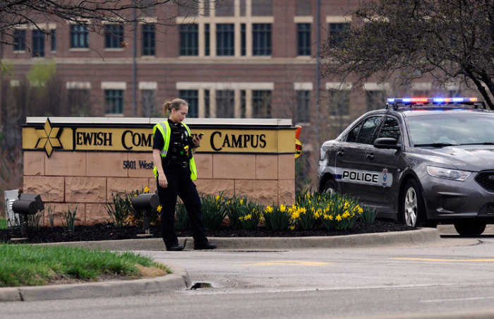 An Overland Park Kansas police officer guards the entrance to the scene of a shooting at the Jewish Community Center of Greater Kansas City in Overland Park, Kansas April 13, 2014. Three people were killed in shootings at Jewish centers in Kansas on Sunday and a suspect was in custody, according to police and local media. The shootings occurred at the Jewish Community Center and at Village Shalom, an assisted living center about a mile away, according to local media.