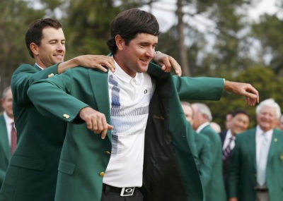 Masters winner Bubba Watson is presented with his green jacket by 2013 winner Adam Scott (L) after winning the Masters golf tournament at the Augusta National Golf Club in Augusta, Georgia, April 13, 2014.