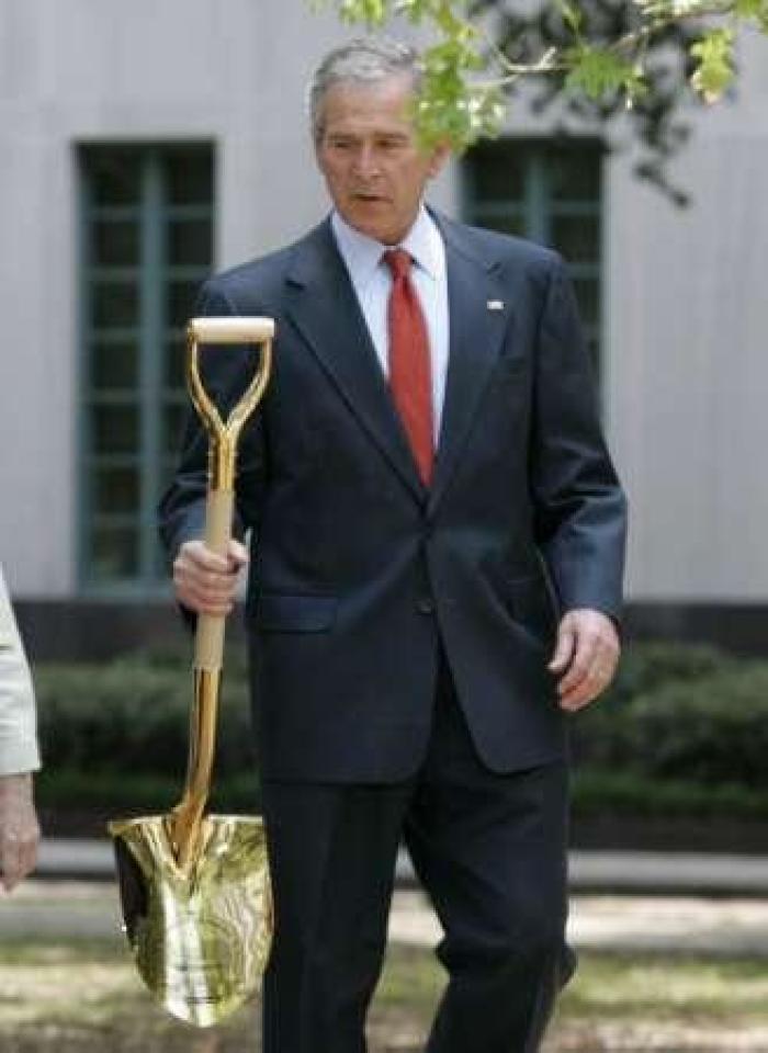 U.S. President George W. Bush grabs a shovel before planting a tree in honor of Earth Day while in New Orleans, Louisiana, April 22, 2008.