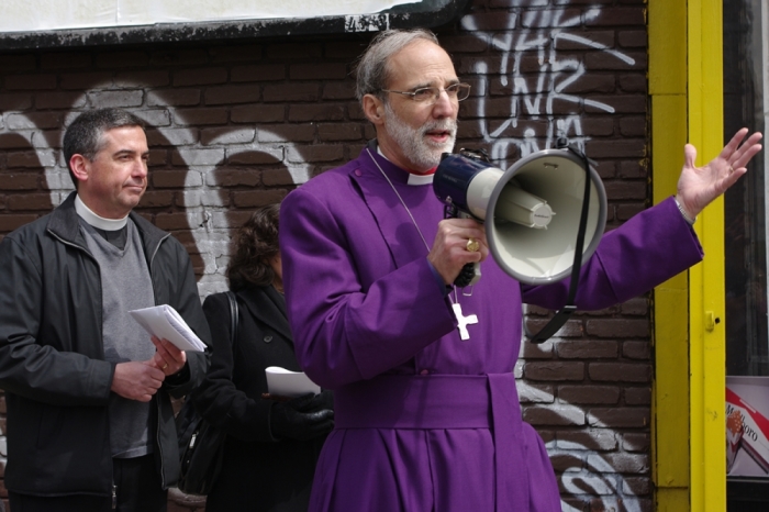 Jersey City churches hold a Stations of the Cross for sites of violent crime in the city. Bishop Mark Beckwith addresses the group at the end of the procession, while the Rev. Thomas Murphy of St. Paul's in Bergen looks on.