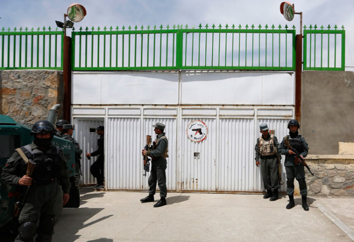 Afghan policemen stand at the gate of Cure Hospital after three foreigners were killed in Kabul April 24, 2014. Three foreigners were killed on Thursday when a security guard opened fire at Cure Hospital, an international hospital, in the Afghan capital,?Kabul, security sources said, in the latest of a series of attacks against foreign civilians.