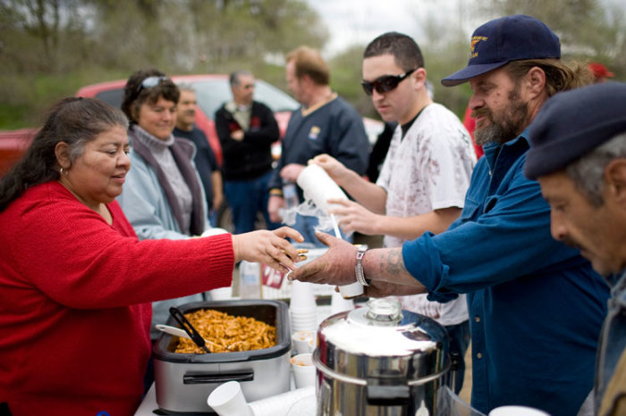 Church volunteers hand out free meals at a homeless tent city in Sacramento, California March 15, 2009.