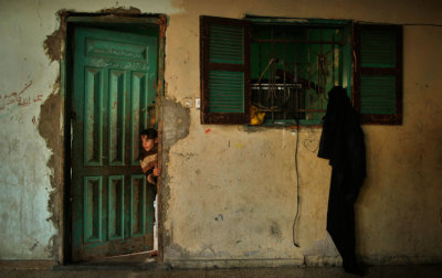 A Palestinian girl looks out from inside her family's house in the northern Gaza Strip March 20, 2014.