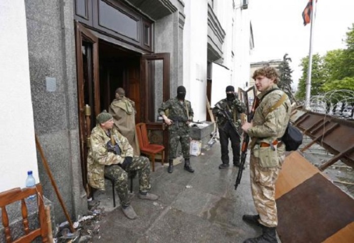 Pro-Russian armed men gather at the entrance to the regional government headquarters in Luhansk, eastern Ukraine, April 30, 2014.