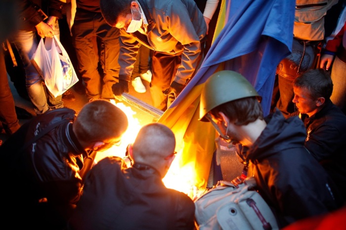 Pro-Russia protesters burn a Ukranian flag outside the district council building in Donetsk, eastern Ukraine on May 4.