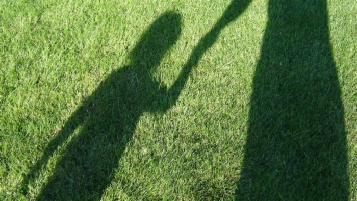 A mother and child captured in a shadow.