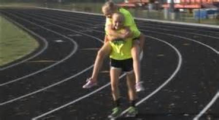 Claire Gruenke, 13, reenacts carrying her twin sister Chloe during the Southern Illinois State track meet May 10, 2014.