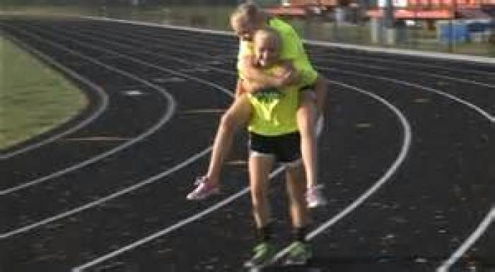 Claire Gruenke, 13, reenacts carrying her twin sister Chloe during the Southern Illinois State track meet May 10, 2014.