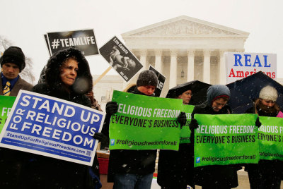 Protesters pray at the steps of the Supreme Court as arguments begin today to challenge the Affordable Care Act's requirement that employers provide coverage for contraception as part of an employee's health care, in Washington March 25, 2014.