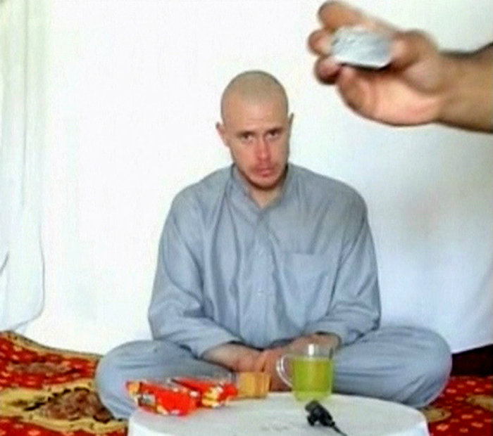 U.S. Army Private Bowe Bergdahl watches as one of his captors displays his identity tag to the camera at an unknown location in Afghanistan, on July 19, 2009.