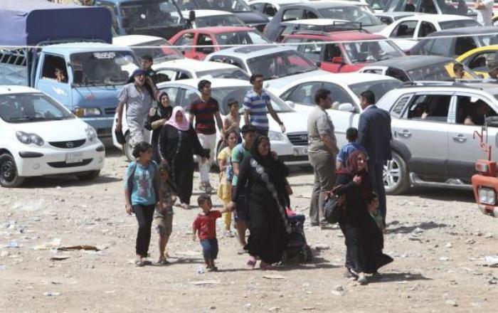 Families fleeing the violence in the Iraqi city of Mosul arrive at a checkpoint in outskirts of Arbil, in Iraq's Kurdistan region, June 10, 2014.