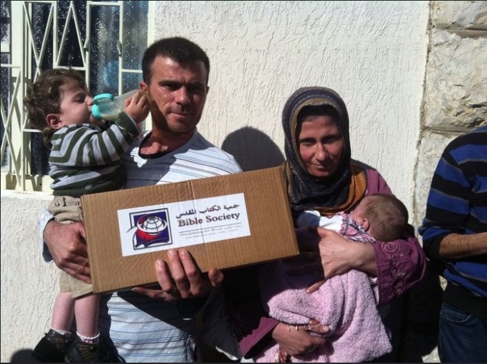 A Syrian refugee family with a Lebanon Bible Society aid package. The Bible Society provides aid for around 3,000 Syrian refugee families.