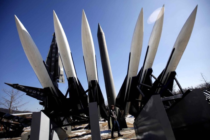 A visitor walks past North Korea's Russian made Scud-B ballistic missile (center, in grey) and South Korea's US-made Hawk surface-to-air missiles at the Korean War Memorial Museum in Seoul on 15 February 2013.