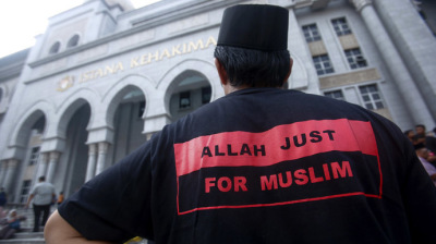 A Muslim man stands outside the court in Putrajaya outside Kuala Lumpur June 23, 2014.