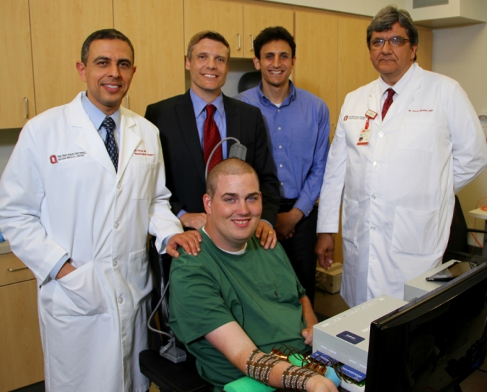 Ian Burkhart, 23, (foreground) poses with Ohio State neuroscience researchers and clinicians (l-r) Dr. Ali Rezai, Chad Bouton, unidentified, and Dr. Jerry Mysiw.