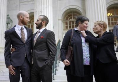 Plaintiffs Derek Kitchen (L-R) and Moudi Sbeity and Kate Call and Karen Archer talk outside the courthouse after a federal appeals court heard oral arguments on a Utah state law forbidding same sex marriage in Denver in an April 10, 2014 file photo.