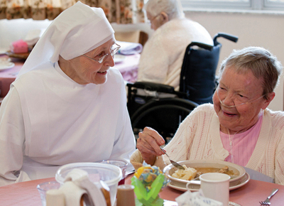 A nun working for the Little Sisters of the Poor cares for an elderly patient.