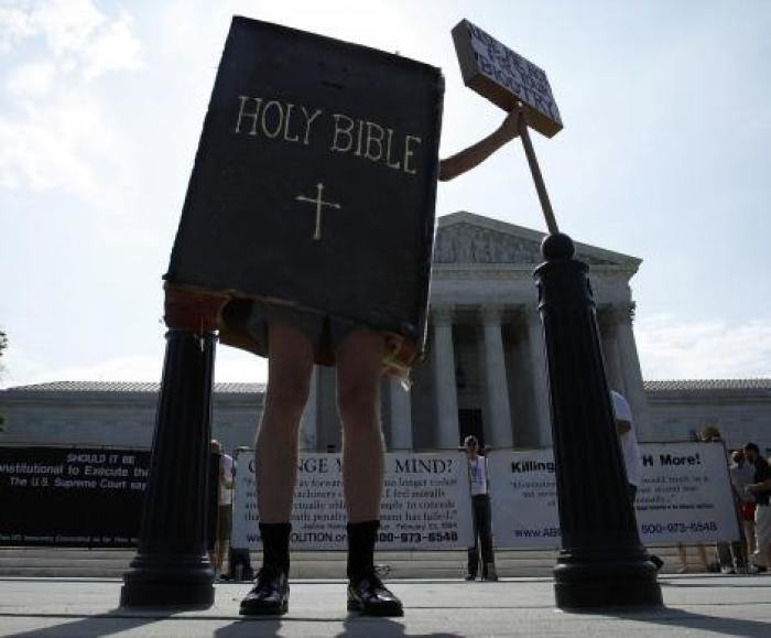A protester dressed as a copy of the Bible joins groups demonstrating outside the U.S. Supreme Court in Washington June 30, 2014.