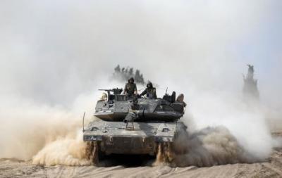 Israeli soldiers ride atop a tank outside the southern Gaza Strip July 7, 2014.