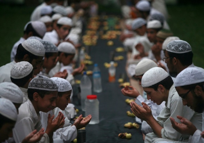 Muslims offer prayers before having their Iftar (fast-breaking) meal during the holy month of Ramadan at a madrasa or religious school on the outskirts of Jammu.