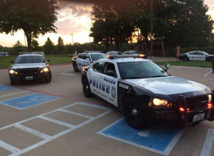 Credit : Police cars are seen on the campus of Oak Cliff Bible Fellowship on Monday, July 7, 2014, in Dallas, Texas, in this photo posted online by Dallas Police Department's Kevin Wetherington.