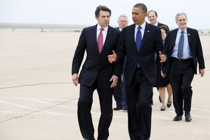 U.S. President Barack Obama walks with Governor Rick Perry as he arrives in Austin, Texas May 9, 2013