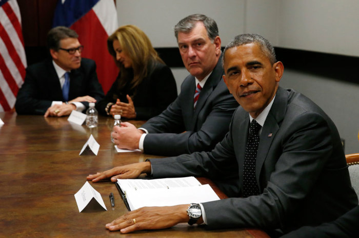 U.S. President Barack Obama (R) meets with Texas Governor Rick Perry (L, rear), local elected officials and faith leaders in Dallas, to discuss a surge of Latin American young people crossing the U.S.-Mexico border, July 9, 2014. Congressional Republicans on Wednesday cast a skeptical eye on a White House request for $3.7 billion to address an influx of child migrants at the U.S. border while Obama met with top critic Perry.