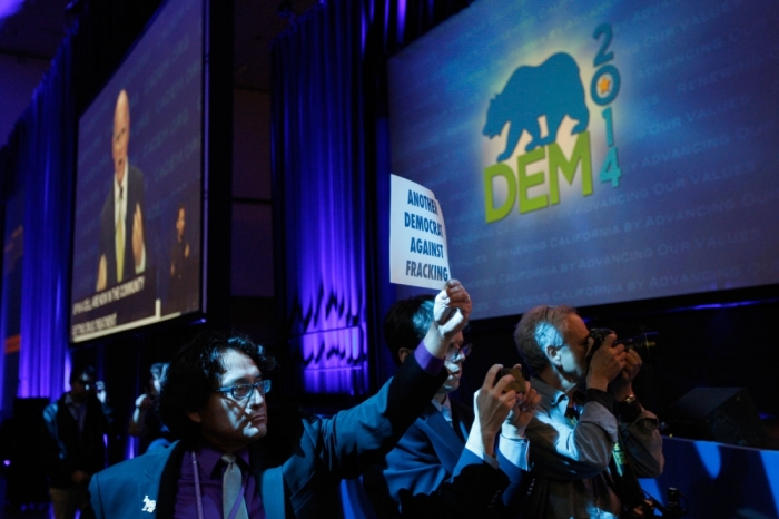 Members of the Democratic Environmental Caucus and other environmental organizations demonstrate against hydraulic fracturing oil extraction, or fracking, as California Governor Jerry Brown (top L) speaks at the 2014 California Democrats State Convention at the Los Angeles Convention Center in Los Angeles, California, March 8, 2014.