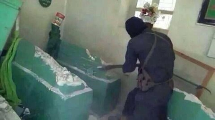 An unverified photo of an ISIL militant destroying the grave of Prophet biblical prophet, Jonah in Mosul, Iraq.