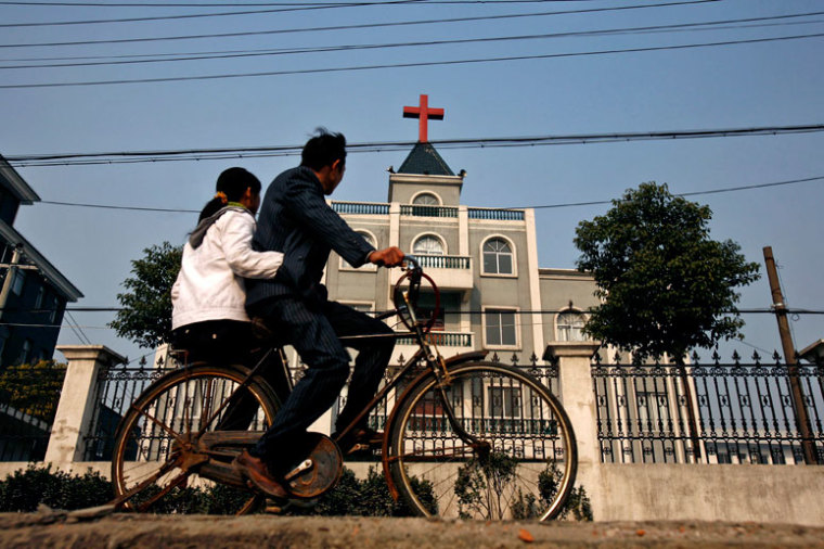 A local resident rides a bicycle past a church in Xiaoshan, a commercial suburb of Hangzhou, the capital of China's east Zhejiang province December 21, 2006.