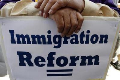 A man holds an immigration reform protest sign during a rally for immigration reform near Senator Dianne Feinstein's office, in Los Angeles, California, April 10, 2013.