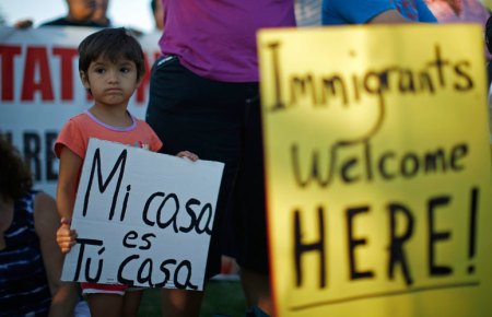 Allisen Stephens, 4, holds a sign at a vigil in support of refugee children and their families in Murrieta, California July 9, 2014. Murrieta has been at the heart of an immigration debate over where to hold and process the surge of illegal migrants crossing the border from Mexico in recent months. The sign reads, "My home is your home."