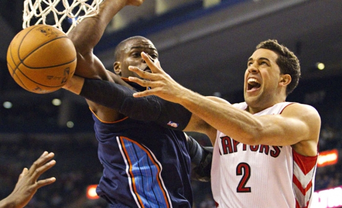 Toronto Raptors' Landry Fields (R) loses the ball on a foul by Charlotte Bobcats' Jeff Adrien in the first half of their NBA basketball game in Toronto, Canada, on Jan. 11, 2013.