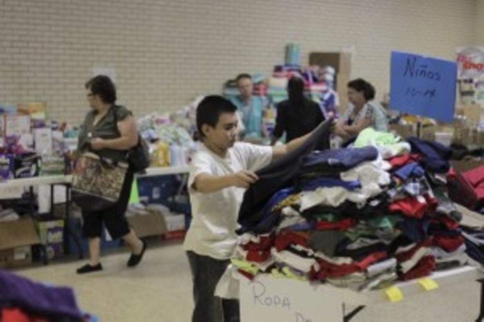 A migrant child chooses clothing at the Sacred Heart Catholic Church temporary migrant shelter in McAllen, Texas, June 27, 2014.