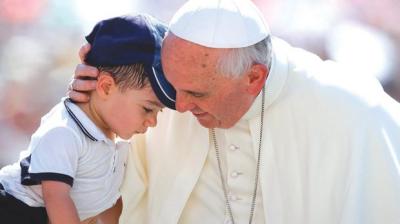 Pope Francis hugging a child during a weekly audience in Saint Peter's Square at the Vatican.