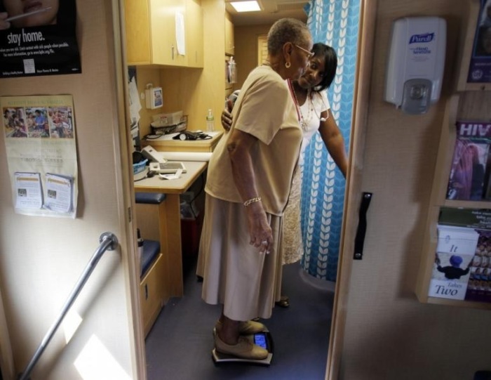 Healthcare educator Rainelle White (rear) checks the weight of client Norma Ferguson. Researchers found a gene, PYHIN1, and its variations may account for a large proportion of asthma risk in people of African descent. The recent study pooled together data from nine independent research groups, including nearly 6,500 patients, about half of which who had asthma.