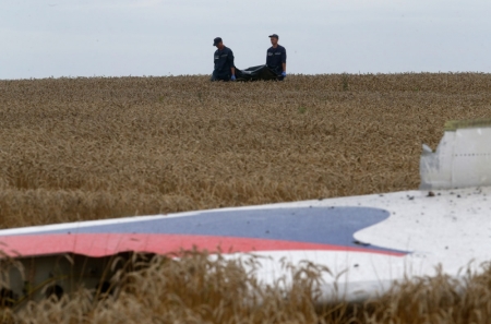 Members of the Ukrainian Emergency Ministry carry a body near the wreckage at the crash site of Malaysia Airlines Flight MH17, near the settlement of Grabovo in the Donetsk region July 19, 2014. Ukraine accused Russia and pro-Moscow rebels on Saturday of destroying evidence of "international crimes" from the wreckage of the Malaysian airliner that Kiev says militants shot down with a missile, killing nearly 300 people.
