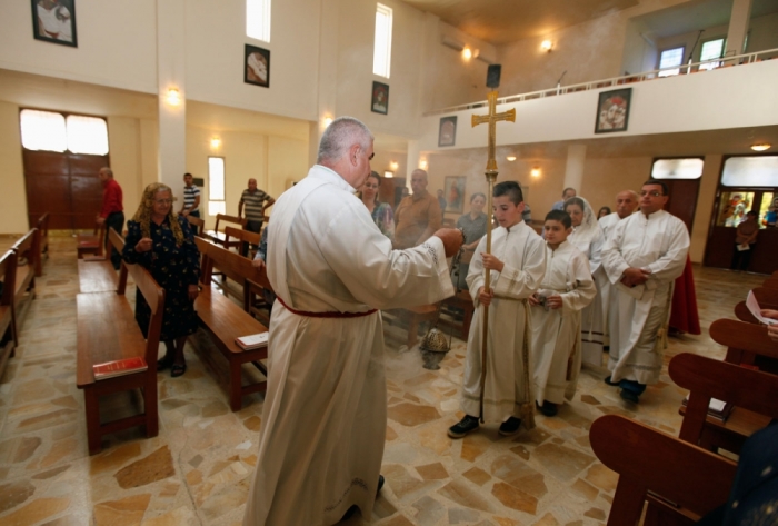 Members of the clergy conduct a mass at St. Joseph Chaldean Church in Baghdad, July 20, 2014.