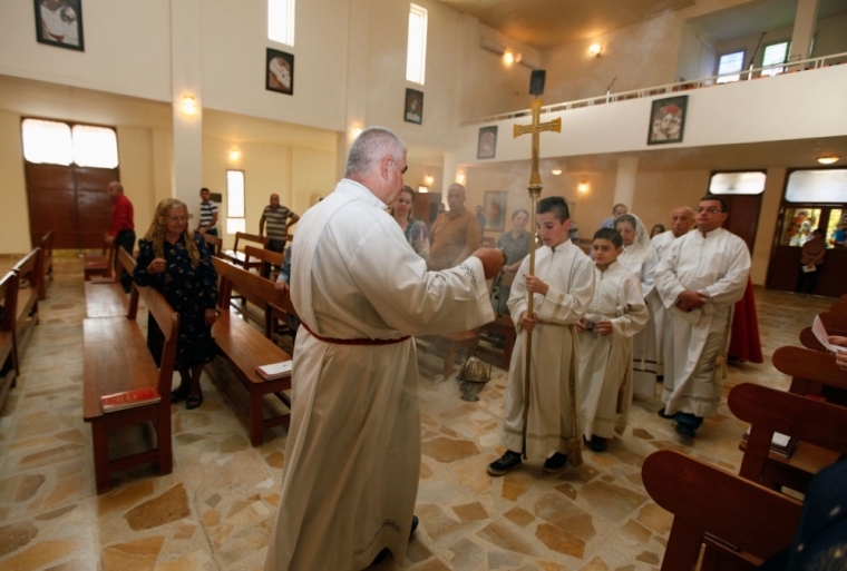 Members of the clergy conduct a mass at St. Joseph Chaldean Church in Baghdad, July 20, 2014. The head of Iraq's largest church said on Sunday that Islamic State militants who drove Christians out of Mosul were worse than Mongol leader Genghis Khan and his grandson Hulagu who ransacked medieval Baghdad. Chaldean Catholic Patriarch Louis Raphael Sako led a wave of condemnation for the Sunni Islamists who demanded Christians either convert, submit to their radical rule and pay a religious levy or face death by the sword.