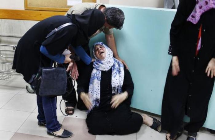 A Palestinian mother (C) mourns the death of her son, who medics said was killed by Israeli shelling, at a hospital in Gaza City July 23, 2014.
