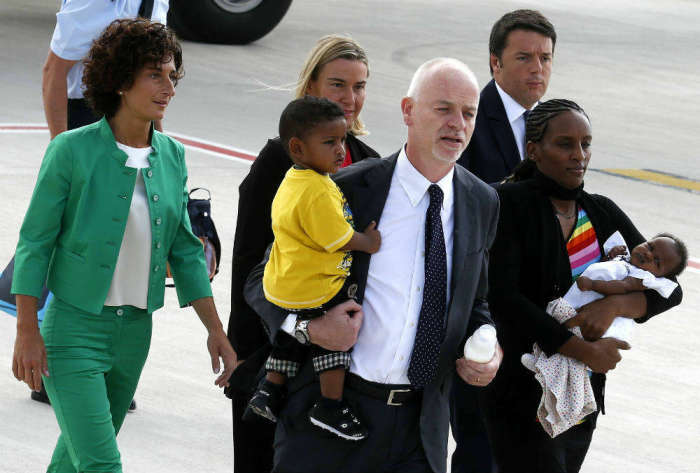 Meriam Yahya Ibrahim of Sudan (2nd R) carries one of her children, as she arrives with Lapo Pistelli (C) Italy's vice minister for foreign affairs, holding her other child, Italian Prime Minister Matteo Renzi (R), his wife Agnese (L) and Foreign Affairs minister Ferica Mogherini after landing at Ciampino airport in Rome July 24, 2014. The Sudanese woman who was spared a death sentence for converting from Islam to Christianity and then barred from leaving Sudan flew into Rome on Thursday.
