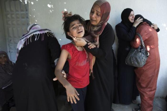 A Palestinian mother comforts her child after what medics said was an Israeli shell that hit a U.N-run school sheltering Palestinian refugees, at a hospital in Jabaliya in the northern Gaza Strip July 24, 2014.