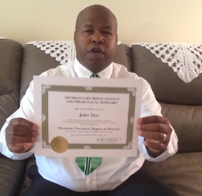Archbishop Derrick Young, president and Chancellor of Abundant Life Bible College and Theological Seminary in Stuart, Florida holds up a sample of the school's honorary doctorate.