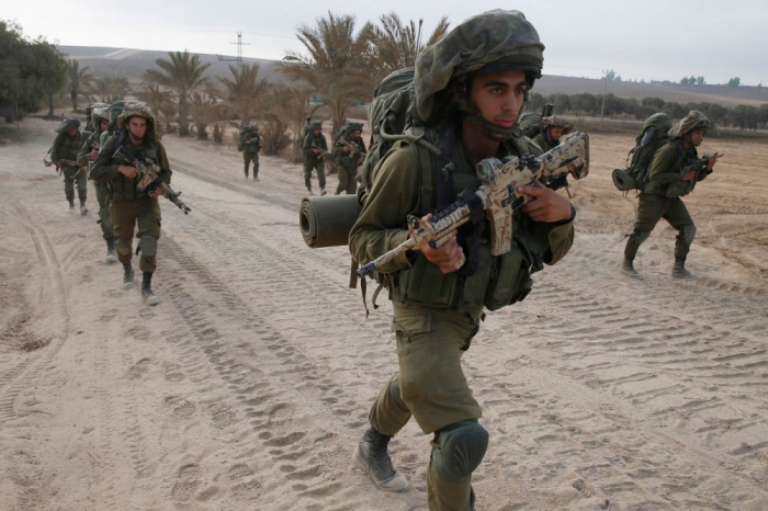 Israeli soldiers walk outside the Gaza Strip as they proceed towards Gaza August 2, 2014. Hamas claimed responsibility on Saturday for a deadly Gaza Strip ambush in which an Israeli army officer may have been captured, but said the incident likely preceded and therefore had not violated a U.S.- and U.N.-sponsored truce. Palestinian officials say 1,653 Gazans, mostly civilians, have been killed. Sixty-three Israeli soldiers have been killed, and Palestinian shelling has killed three civilians in Israel. Israel launched a Gaza air and naval offensive on July 8 following a surge of cross-border rocket salvoes by Hamas and other Palestinian guerrillas, later escalating into ground incursions centred along the tunnel-riddled eastern frontier of the enclave but often pushing into residential areas.