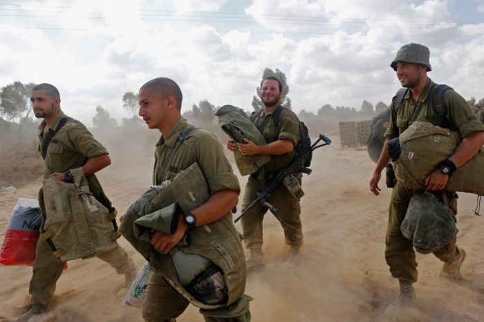 Israeli soldiers arrive at a staging area near the border with Gaza Strip August 4, 2014. Palestinians accused Israel of breaking its own ceasefire on Monday by launching a bomb attack on a refugee camp in Gaza City that killed an eight-year-old girl and wounded 29 other people. An Israeli military spokeswoman said she was checking the report.