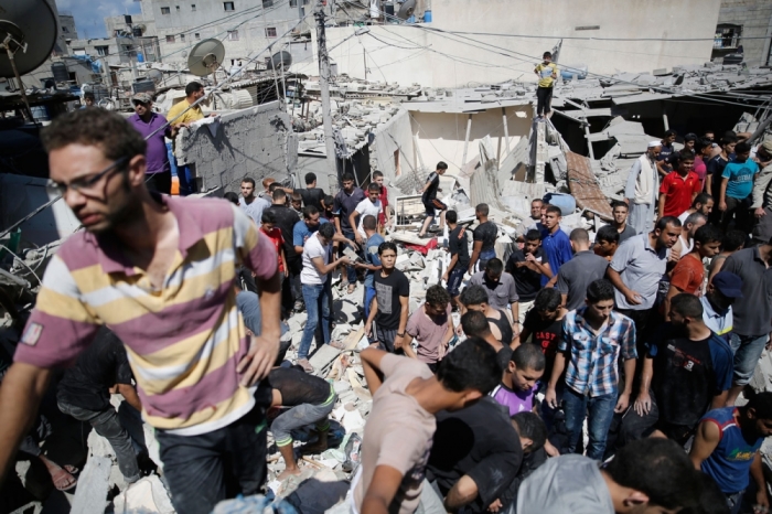 Palestinians dig through the rubble of a building searching for bodies after what police said was an Israeli air strike at Shati (Beach) refugee camp in Gaza City August 4, 2014.
