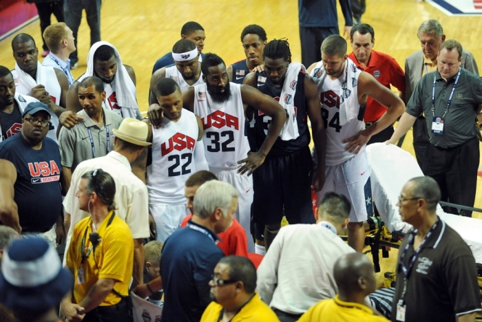 The USA Basketball team players and coaching staff look on as guard Paul George is tended to by medical personnel after suffering a leg injury during the USA Basketball Showcase at Thomas & Mack Center.