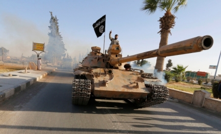Militant Islamist fighters on a tank take part in a military parade along the streets of northern Raqqa province June 30, 2014. Militant Islamist fighters held a parade in Syria's northern Raqqa province to celebrate their declaration of an Islamic